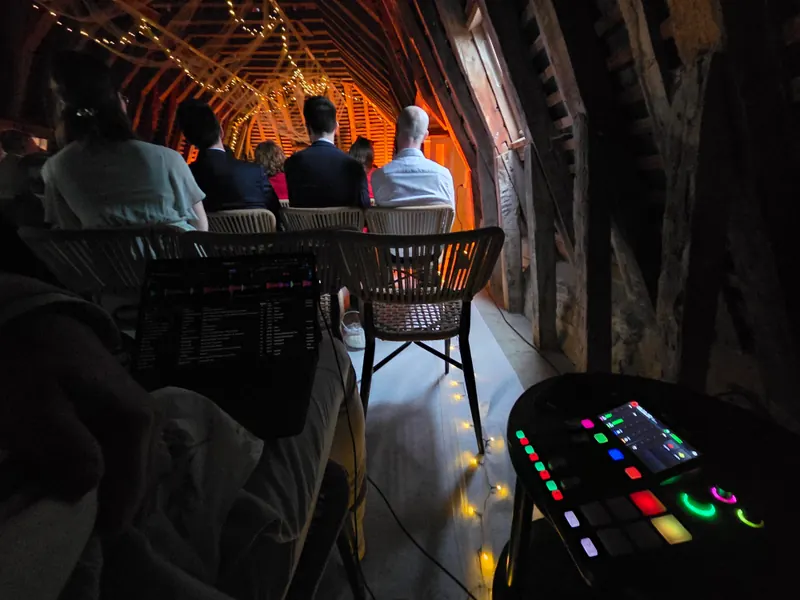Régie DJ installée pour une cérémonie sous une grange en lumières